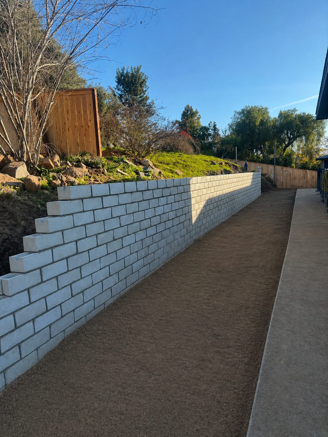 Stepped concrete block retaining wall along side yard in San Diego